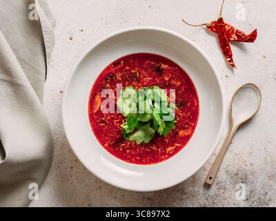 Traditionelle rote Suppe Borschtsch mit Roter Bete. Nationale russische und ukrainische Suppe, Küche, Essen. Leckere Rote-Bete-Suppe mit Gemüse in einer Schüssel auf Neutra Stockfoto