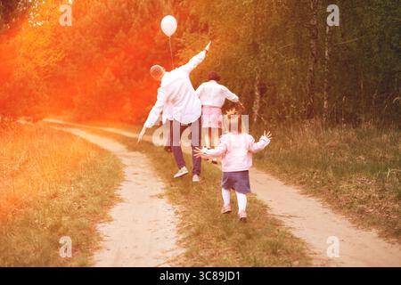 Glückliche Familie mit einem Kind, das im Park spaziert Stockfoto