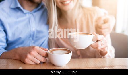 Kurzer Blick auf ein romantisches Paar, das Kaffee trinkt und sich umarmt Café Stockfoto