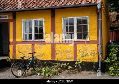 Gelbes Fachwerkhaus mit Fahrrad im dänischen Dorf Stockfoto
