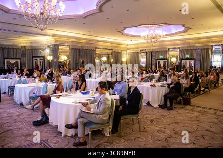 Konferenzteilnehmer sitzen an Tischen Stockfoto