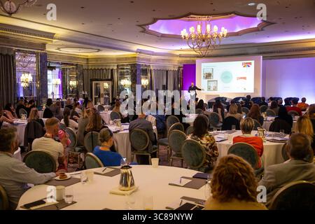 Konferenzteilnehmer sitzen an Tischen Stockfoto
