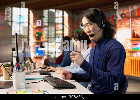 Wütender Callcenter-Agent im Büro streitet mit unhöflichen Kunden, die sich während des Anrufs beschweren. Verärgerter Kundendienstmitarbeiter, der unfreundliche Kunden mit Problemen im Zusammenhang mit Dienstleistungen beschimpft Stockfoto