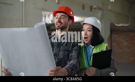 Multinationale glückliche Ingenieure Bau Teamwork Baustelleninspektion Blueprint Diskussion Erfolg Sicherheit Fortschritt Planung diverse Mitarbeiter Geschäft Stockfoto