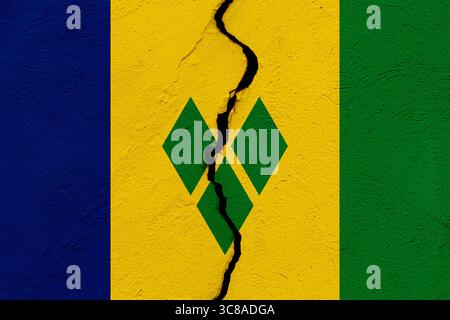 Die Flagge von St. Vincent und den Grenadinen in eine zerrissene Mauer. Geopolitik und Naturkatastrophen-Konzept Stockfoto