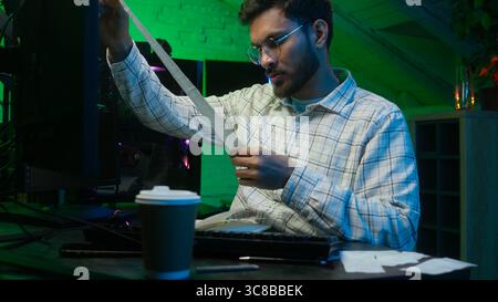 Gestresster verärgerter indischer arabischer Mann, der Informationen überprüft, Rechnungen Code männlich, der Computermonitor Händler Guy Programmierer Programmierer Coder Arbeiter freiberuflich betrachtet Stockfoto