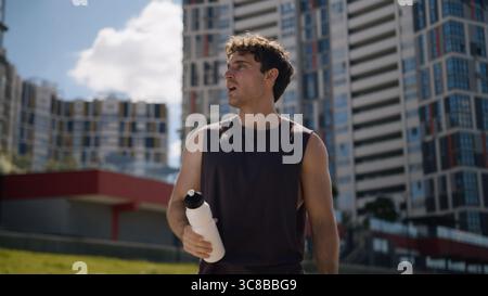 Kaukasischer Mann Athlet männlicher Mann Sport Trinkflasche Wasser Erfrischung Workout Stadt außerhalb Fitness Läufer gesunder Sportler Durst Gesundheit Wellness Stockfoto