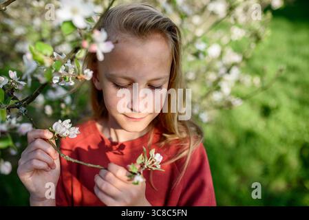 Mädchen genießt Frühlingsblüten im Garten. Stockfoto