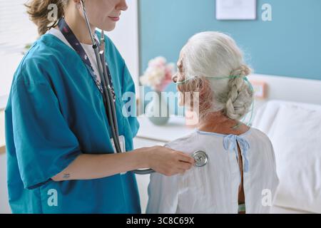 Ärztin untersucht ältere kaukasische Frau mit Stethoskop im Krankenhaus Stockfoto