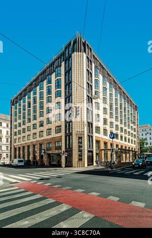Ein markantes, mehrstöckiges modernes Stadtgebäude unter klarem blauem Himmel an einer Straßenkreuzung in Wien, Österreich. Stockfoto