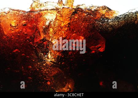 Erfrischende Cola in Glas mit Eis auf weißem Hintergrund gießen, Nahaufnahme Stockfoto