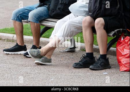 Stuttgart, Deutschland. August 2025. Drei Personen sitzen zusammen auf einer Bank in einem öffentlichen Raum. Quelle: Markus Lenhardt/dpa/Alamy Live News Stockfoto