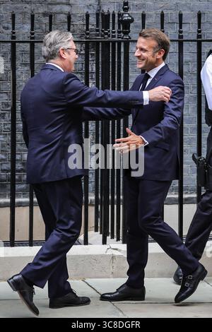 Sir Keir Starmer begrüßt und umarmt den französischen Präsidenten Emmanuel Macron, Downing Street, Großbritannien Stockfoto