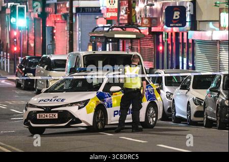 High Street, Cradley Heath, 4. August 2025: Polizei und Forensiker von West Midlands am Tatort eines Doppelerstochs in der Cradley Heath High Street am Sonntag, den 3. Abend. Zwei Männer im Alter von 22 und 42 Jahren erstochen sich gegenseitig in der Region Sandwell in den West Midlands. Die Polizisten haben die verletzten Männer wegen des Verdachts auf versuchten Mord verhaftet. Ein Laden, in dem der Angriff stattfand, war voller erster Hilfe und Kleidung. Kleine Blutflächen waren auch auf dem Boden zu sehen. WMP-Erklärung: "Zwei Männer wurden nach einer Störung in Cradley Heath verhaftet. „Wir wurden gestern Abend (3. August) gegen 20:20 Uhr angerufen Stockfoto