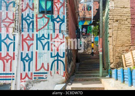 Steile Treppen und Wandmalereien sind im Viertel Mähren zu sehen, das einst eine kommunale Deponie in Medellin, Kolumbien, war Stockfoto