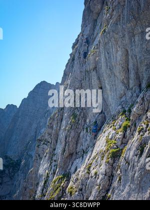 Anonyme Kletterer, die den Klettersteig auf dem Mangart Berg, Slowenien, Triglav Nationalpark besteigen. Stockfoto
