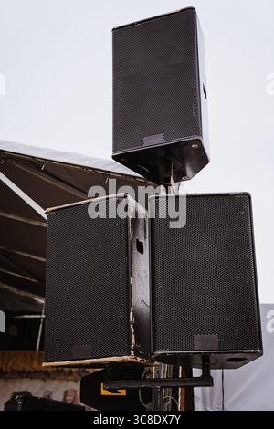 Installation von drei großen schwarzen Lautsprechern auf einem Metallrahmen für den Außenbereich. Stockfoto