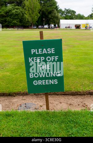Ein Schild, auf dem die Leute höflich aufgefordert werden, „Bitte halten Sie sich vom Bowlinggrün ab“ in Lowther Gardens in Lytham, Lancashire, Großbritannien Stockfoto