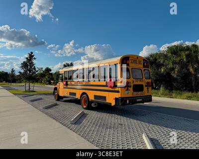 Typischer amerikanischer Schulbus in Florida, leuchtend gelb mit schwarzen Details, im Freien geparkt. Stockfoto