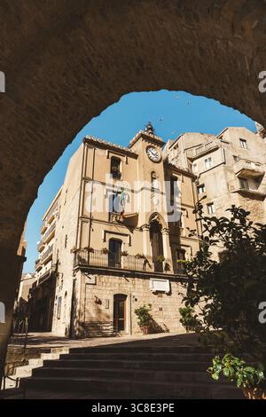 Historisches Gebäude mit Uhrenturm in Gangi, Sizilien, Blick durch einen Steinbogen Stockfoto