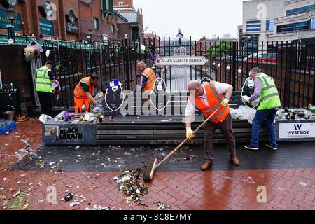 Mitarbeiter und Freiwillige des Stadtrates von Birmingham beginnen, die Blumen und Tribut zu entfernen, die Ozzy Osbourne an der Black Sabbath Bridge Bank in der Broad Street in Birmingham hinterlassen hat. Black Sabbath Frontmann Ozzy starb letzten Monat im Alter von 76 Jahren. Bilddatum: Montag, 4. August 2025. Stockfoto