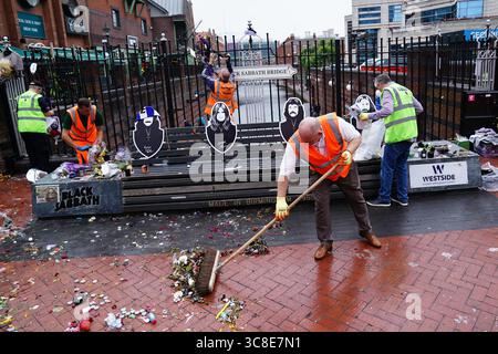 Mitarbeiter und Freiwillige des Stadtrates von Birmingham beginnen, die Blumen und Tribut zu entfernen, die Ozzy Osbourne an der Black Sabbath Bridge Bank in der Broad Street in Birmingham hinterlassen hat. Black Sabbath Frontmann Ozzy starb letzten Monat im Alter von 76 Jahren. Bilddatum: Montag, 4. August 2025. Stockfoto