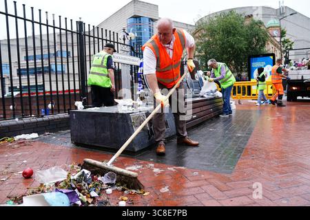 Mitarbeiter und Freiwillige des Stadtrates von Birmingham beginnen, die Blumen und Tribut zu entfernen, die Ozzy Osbourne an der Black Sabbath Bridge Bank in der Broad Street in Birmingham hinterlassen hat. Black Sabbath Frontmann Ozzy starb letzten Monat im Alter von 76 Jahren. Bilddatum: Montag, 4. August 2025. Stockfoto