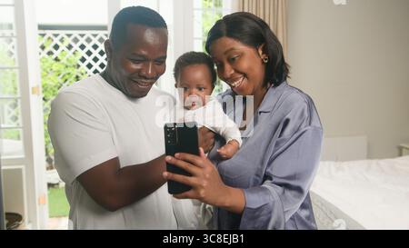 Glückliche Familie, die gemeinsam ein Selfie in einem hellen Zuhause macht Stockfoto