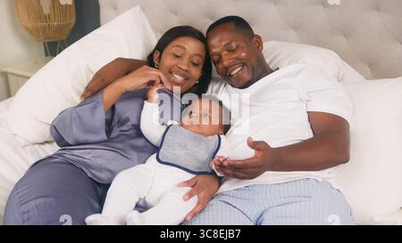 Happy Family Bonding Moment Relaxing im Bett mit ihrem Kleinkind Stockfoto