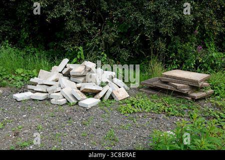 Alte Pflasterplatten und Betonblöcke stapelten sich auf einem ländlichen Bauernhof Stockfoto