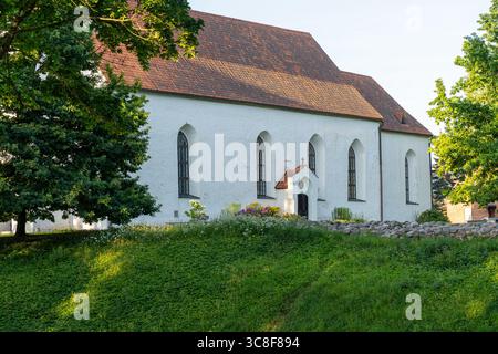 Seitenansicht der Johanniskirche von Viljandi (Jaani kirik) mit weißen Wänden, rotem Ziegeldach und gotischen Fenstern umgeben von Grün, Estland Stockfoto