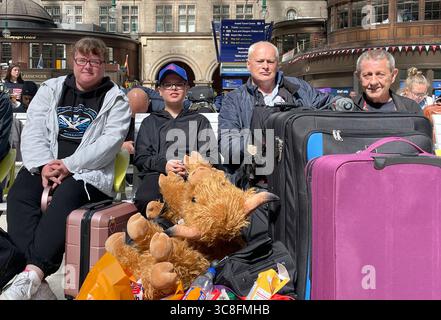 (Von links nach rechts) Frances Kusz, Jack Kusz, Paul Audoire und Robert Kusz, die von Ayr nach Blackpool reisen, warten am Glasgow Central Station, da sie mit Verspätungen und mehrfachen Annullierungen konfrontiert sind, da Storm Floris zu Störungen des Schienennetzes führt. Bilddatum: Montag, 4. August 2025. Stockfoto