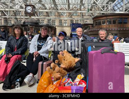 (Von links nach rechts) Melissa Kusz, Frances Kusz, Jack Kusz, Paul Audoire und Robert Kusz, die von Ayr nach Blackpool reisen, warten am Glasgow Central Station, da sie mit Verspätungen und mehrfachen Annullierungen konfrontiert sind, da Storm Floris zu Störungen des Schienennetzes führt. Bilddatum: Montag, 4. August 2025. Stockfoto