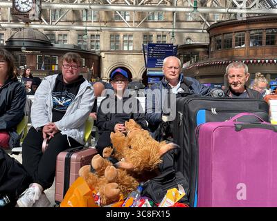 Die Familie Kusz in Glasgow Central Station, Glasgow, als sie versuchen, von der Stadt zu ihrem Zuhause in Blackpool zu gelangen. Wetterwarnungen treten in Kraft, und Sturm Floris wird voraussichtlich zu schweren Fahrstörungen im Straßen-, Luft- und Fährverkehr sowie zum Schließen von Brücken führen. Die Warnzone umfasst Schottland, Teile Nordirlands, Nordwales und Nordengland. Bilddatum: Montag, 4. August 2025. Stockfoto