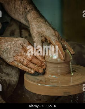 Nahaufnahme einer Töpferhand, die einen Topf auf einem Töpferrad formt. Stockfoto