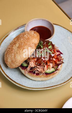 Köstliches Pulled Pork Sandwich mit Barbecue Sauce serviert auf einem gerösteten Brötchen mit Krautsalat. Klassisches amerikanisches Komfortessen, perfekt für BBQ und Mittagessen Stockfoto