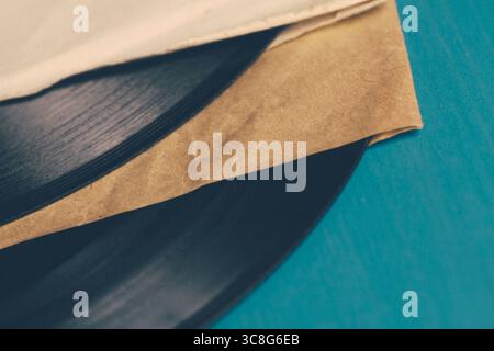 Nahaufnahme von Vintage-Schallplatten und ihren Hüllen, die eine nostalgische und Retro-Atmosphäre schaffen, die die reiche Geschichte der Musik feiert Stockfoto