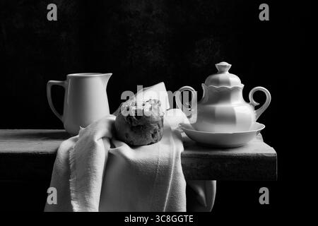 Stilleben im barocken Stil mit einer Teekanne aus Steingut und einer Zuckerschale auf einem Holzbrett und einer weißen Tischdecke IV, europa Stockfoto