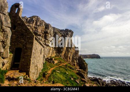 Die kleine St. Govans Chapel, versteckt an den Kalksteinklippen der Küste von Pembrokeshire in Wales Stockfoto