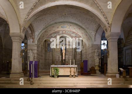 Innenansicht des unteren Kirchenaltars in San Fermo Maggiore (Chiesa Inferiore), Verona, Italien, mit romanischen Gewölben und einem Kruzifix. Stockfoto