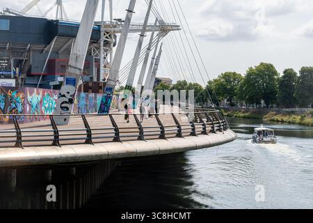 Principality Stadium am Fluss Taff, dem Nationalstadion von Wales, mit Menschen auf dem Millennium Walkway, Cardiff City, South Wales, Großbritannien Stockfoto