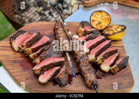 Scheiben von Rumpcap-Rindfleisch, gekocht auf einem kadai oder einer offenen Feuerschüssel. Stockfoto