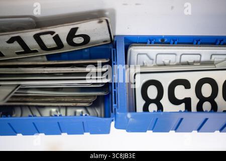 Berlin, Deutschland. August 2025. Alte Kennzeichen abgemeldeter Fahrzeuge und neue Kennzeichen (r) in einem Autokennzeichen-Lager bei der Kfz-Zulassungsstelle in Friedrichshain-Kreuzberg. Quelle: Sebastian Gollnow/dpa/Alamy Live News Stockfoto