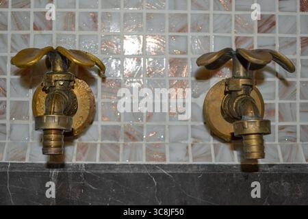 Zwei Vintage-Wasserhähne in Blütenform mit kaltem und heißem Wasser im Badezimmer Stockfoto