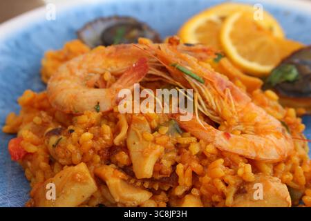 Paella mit Meeresfrüchten und lapas (Limetten) und Zitrone, traditionelles kanarisches Gericht, das auf Lanzarote, den Kanarischen Inseln, Spanien serviert wird. Stockfoto