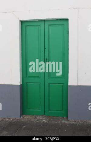 Traditionelle grüne Holztür in Arrecife, Lanzarote, Kanarischen Inseln, mit typischer Inselarchitektur und lebendigen Farbdetails. Stockfoto