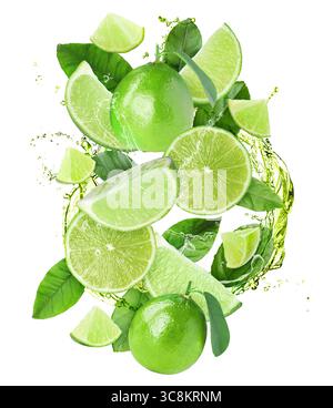 Frische Limetten und Spritzwasser in der Luft vor weißem Hintergrund Stockfoto