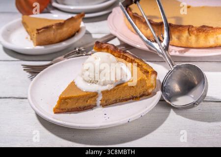 Traditioneller Herbst-Kürbiskuchen. Süßes Thanksgiving-Abendessen, saisonaler Herbst-Kuchen mit Kürbis-Kürbis, Zimt, mit Vanilleeis und Kugeln auf Woo Stockfoto