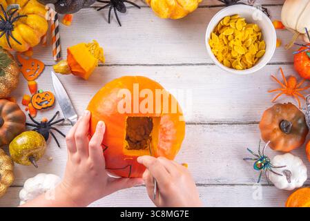 Halloween-Vorbereitung mit schnitzendem Kürbis Jack Lantern. Frauen, Frauen und Kinder Hände im Rahmen, dekorieren, zeichnen und schnitzen gruselige Hallowe Stockfoto