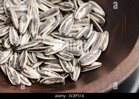 Geröstete Sonnenblumenkerne in rustikaler Holzschale Nahaufnahme. Stockfoto